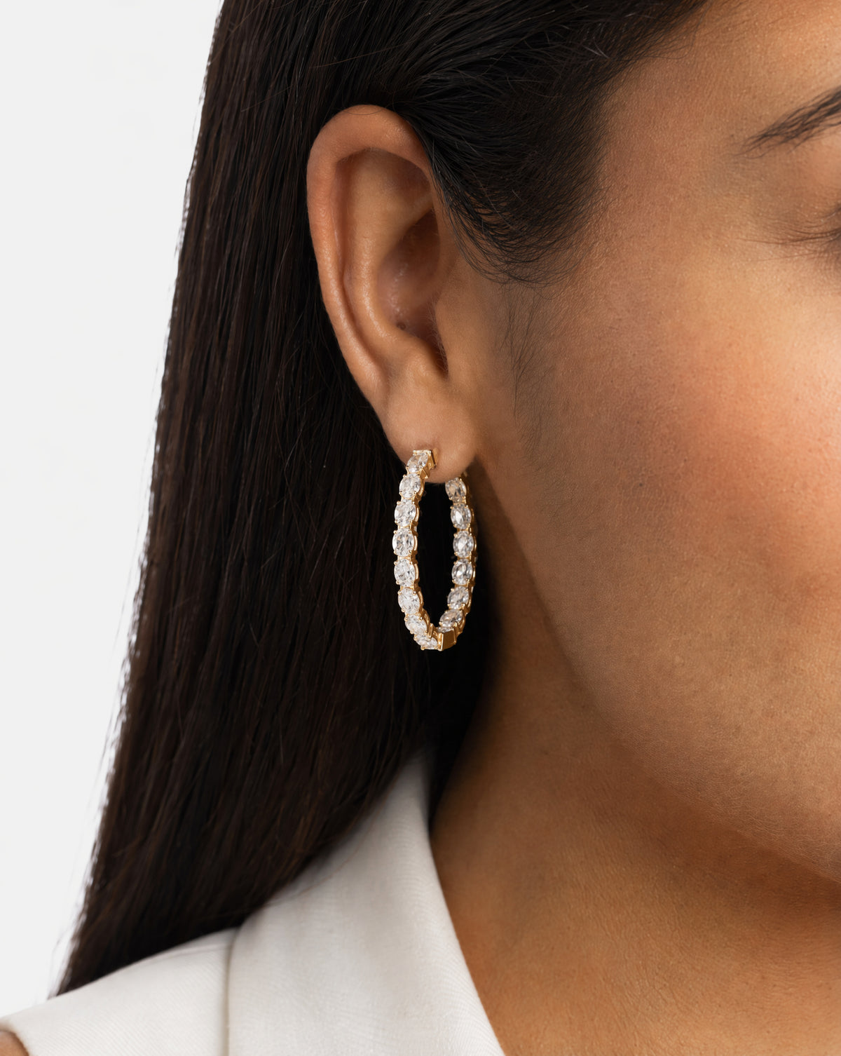 Model wearing oval diamond hoop earrings in gold #Gold